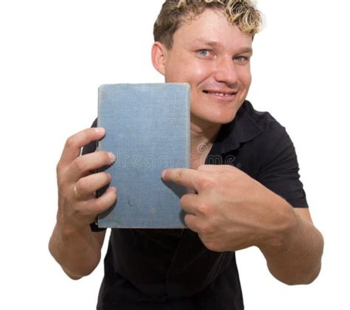 a man holding a book in his right hand