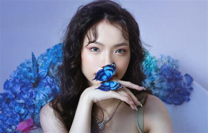 a woman holding a butterfly in front of her face