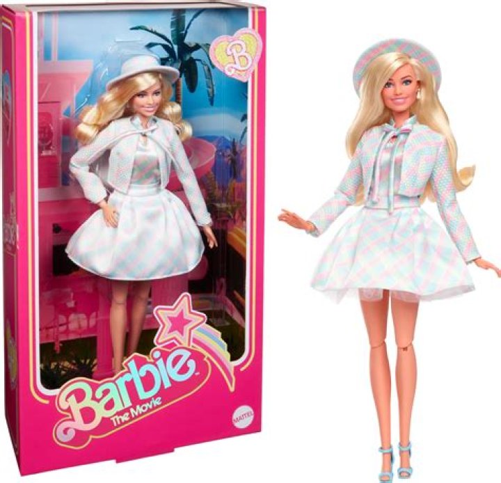 the barbie doll is wearing a blue shirt and has a name tag on her chest